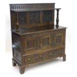 A Victorian carved oak court cupboard with a dentil moulded shelf above turned tapering supports and