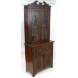 A late 19thC / early 20thC mahogany secretaire bookcase with a carved shaped pediment above two