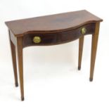A serpentine mahogany serving table with brass back plates and handles flanked by marquetry inlaid