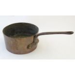 A large Victorian copper sauce pan with cast iron looped handle, stamped ' C R ' , 10" in