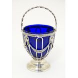 A silver sugar basket with swing handle and blue glass liner. Hallmarked Chester 1908 maker