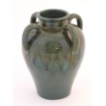 A large four handled vase of baluster form with green drip glaze. Approx. 10 1/2" high Please Note -