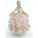 A Dresden model of a lady with a porcelain lace dress. Marked under. Approx. 5 3/4" high Please Note