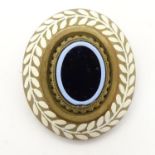 A gilt metal brooch with enamel decoration. Approx. 1 1/2" long Please Note - we do not make