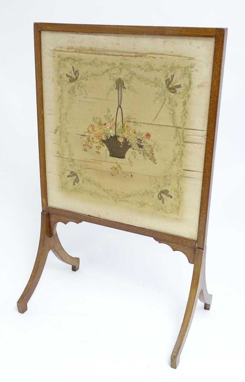 An early 19thC silk needlework with fine floral decoration, bows, swags and a woven basket in a