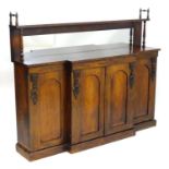 A 19thC rosewood sideboard having a shelf mounted by turned finials and raised by tapering