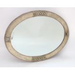 An Arts and crafts oval mirror with a hammered metal frame and bevelled glass centre. 36" wide x 26"