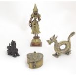 Four brass and cast metal Oriental items comprising a deity figure, a dragon, a foo dog stand and