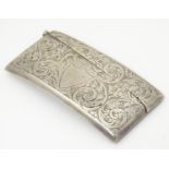 A silver visiting card case of shaped form with engraved acanthus scroll decoration. Hallmarked