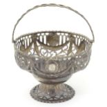 A 19thC white metal basket of pedestal form with pierced decoration and embossed bird and swag