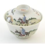 A Chinese tea bowl and cover decorated with a landscape scene with a figure on horseback, a bridge