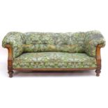 A Victorian oak framed Chesterfield settee, with scrolled and carved arms above floral detailing and