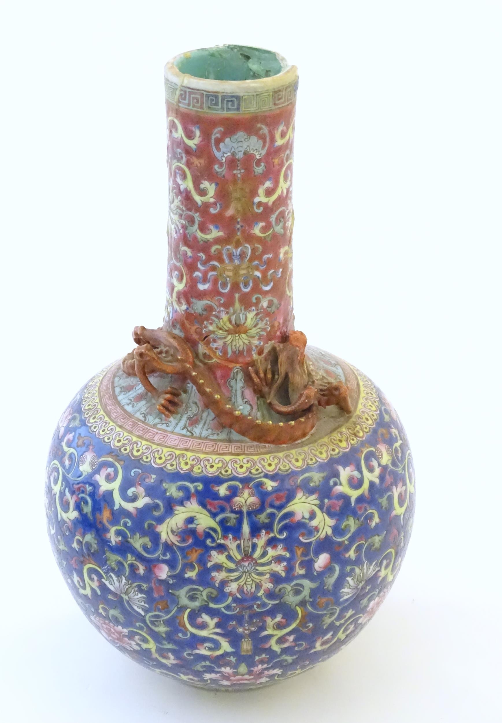 A Chinese bottle vase with scrolling floral and foliate detail, and applied dragon decoration to