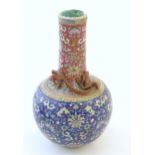A Chinese bottle vase with scrolling floral and foliate detail, and applied dragon decoration to
