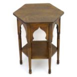 An early 20thC Liberty style oak Moorish table with a hexagonal top above six Moorish arches and
