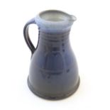 A studio pottery jug with a blue glaze, ribbed neck and banded detail. Impressed mark to under