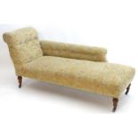 A late 19thC Victorian chaise longue with a scrolled backrest and armrest, having a sprung seat