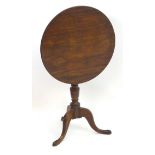 A late 19thC mahogany tilt top tripod table, with a turned pedestal and three cabriole legs