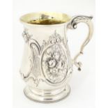 A Victorian silver mug with embossed decoration and gilded interior. Hallmarked London 1864 maker