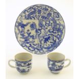 An Oriental blue and white plate decorated with figures and scrolling flowers and foliage. With blue