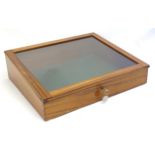 A mid 20thC mahogany shadow box with exposed dovetailing and a glazed lid opening to show a baize