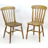 Two late 19thC Windsor side chairs with elm seats and turned tapering legs united by a H