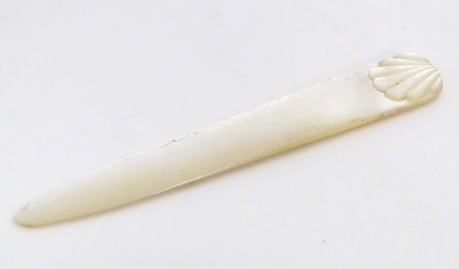 An early 20thC mother of pearl letter opener with shell detail. Approx. 4 1/4" Please Note - we do