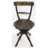 An early 20thC oak and beech chair with a shaped top and mid rail united by tapering supports,