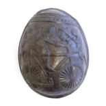 An African carved coconut in two sections depicting a figure on bicycle, stylised animals and