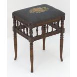 An Edwardian piano stool with floral needlework top with turned finial supports above four turned