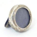 A silver miniature photograph frame of circular form. Approx 1 1/4" diameter Please Note - we do not