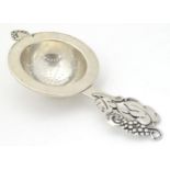 Scandinavian silver : A silver strainer with styles fruiting vine decoration to handle maker Carl M.