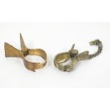 Two early 20thC gilt metal skirt lifters formed as clasped hands, the largest 2" long Please