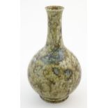 A Chinese bottle vase with a mottled glaze decorated with a stylised dragon face and claws, and