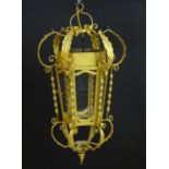 A gilt metal pendant lantern of hexagonal form with scrolled detail, approx. 27" tall Please