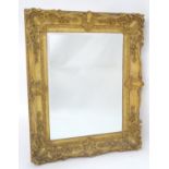 A 19thC giltwood and gesso moulded mirror with a central bevelled glass centre. 37" wide x 31" high.