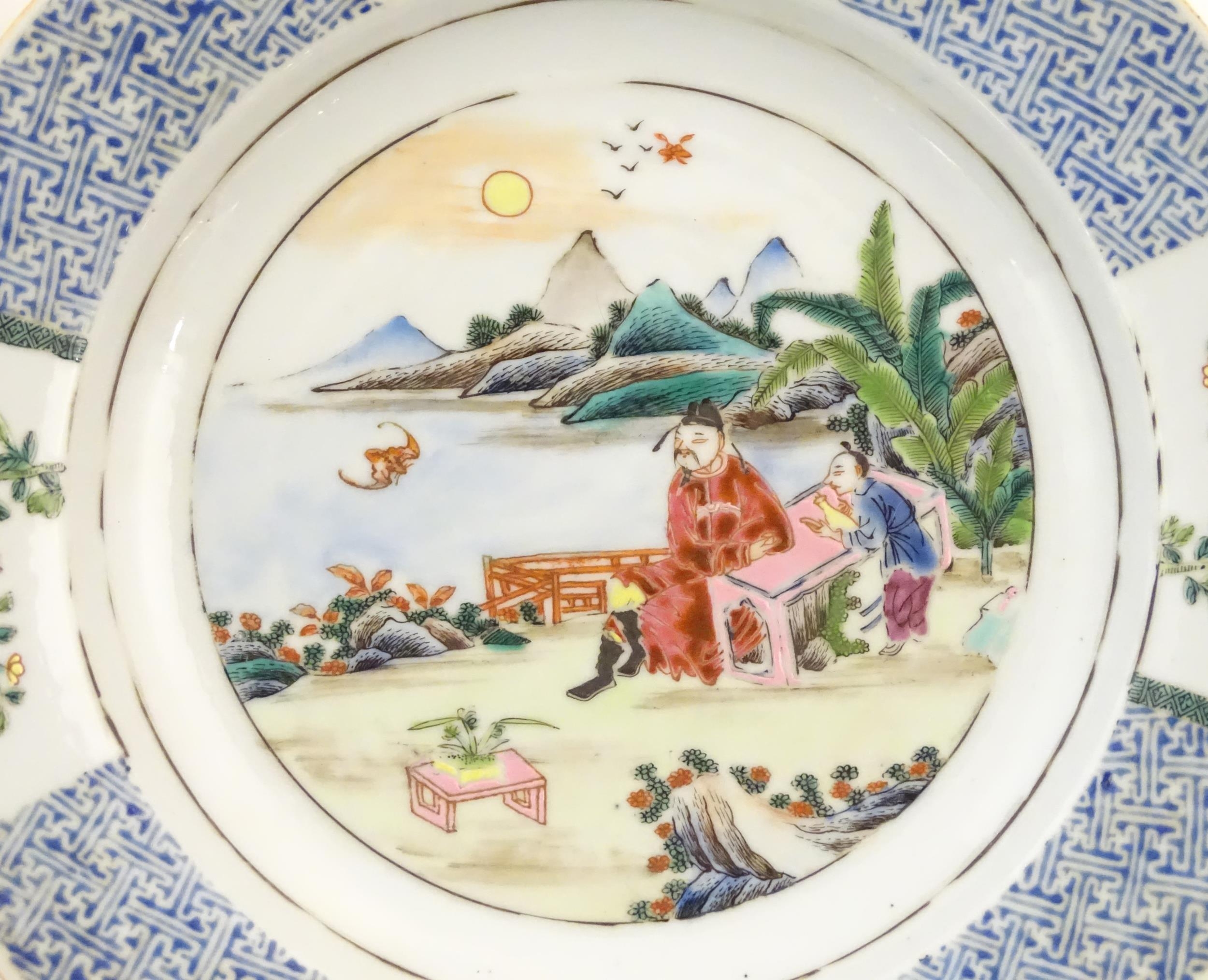 A pair of Chinese plates depicting a two figures in a garden watching a bat, with sea and - Image 4 of 5