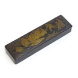 An early 20thC lacquered papier mache pen box decorated with a garden scene with Oriental figures