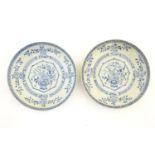 A pair of Chinese blue and white plates with central vase with peonies and blossom, the border