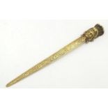 An early 20thC brass letter opener with classical head finial and grape and vine detail to blade.