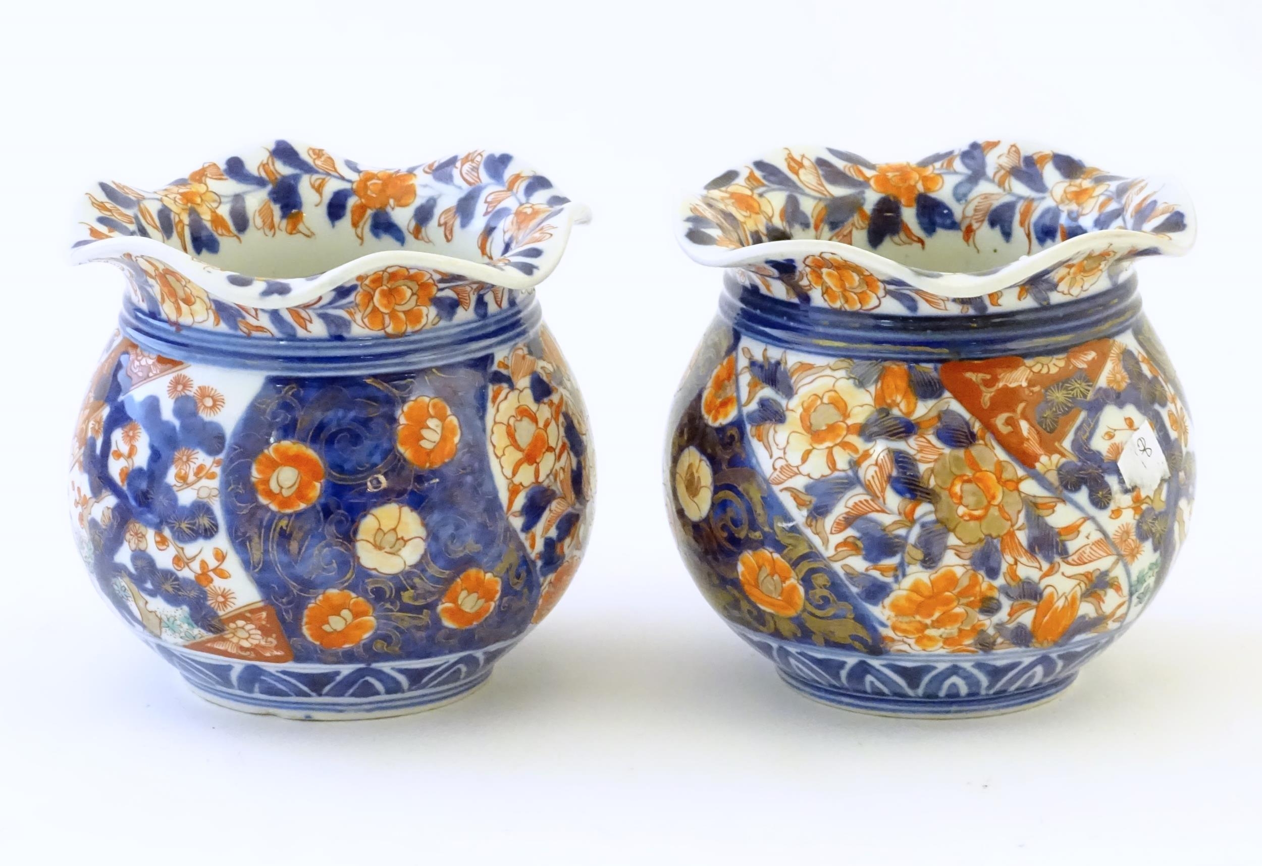 Two Oriental vases of bulbous form with flared rims decorated in the Imari palette with flowers