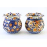 Two Oriental vases of bulbous form with flared rims decorated in the Imari palette with flowers