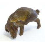 A 20thC cast model of a pig scratching its ear. Approx. 2" wide Please Note - we do not make