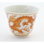 A Chinese wine cup with dragon detail and stylised flaming pearls and clouds. Character marks under.