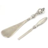 A silver handled shoe horn, together with a silver handled manicure tool. The shoe horn 7" long (