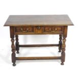 An early 18thC oak side table with an overhanging top above a single long drawer with brass handles,