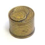 A 20thC Continental cast inkwell modelled as stacked coins, with applied French coins to top.