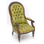 A Victorian mahogany armchair with a moulded frame and deep buttoned leather upholstery with brass