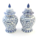 A pair of Chinese lidded vases of baluster form, decorated with stylised fruit and foliage with