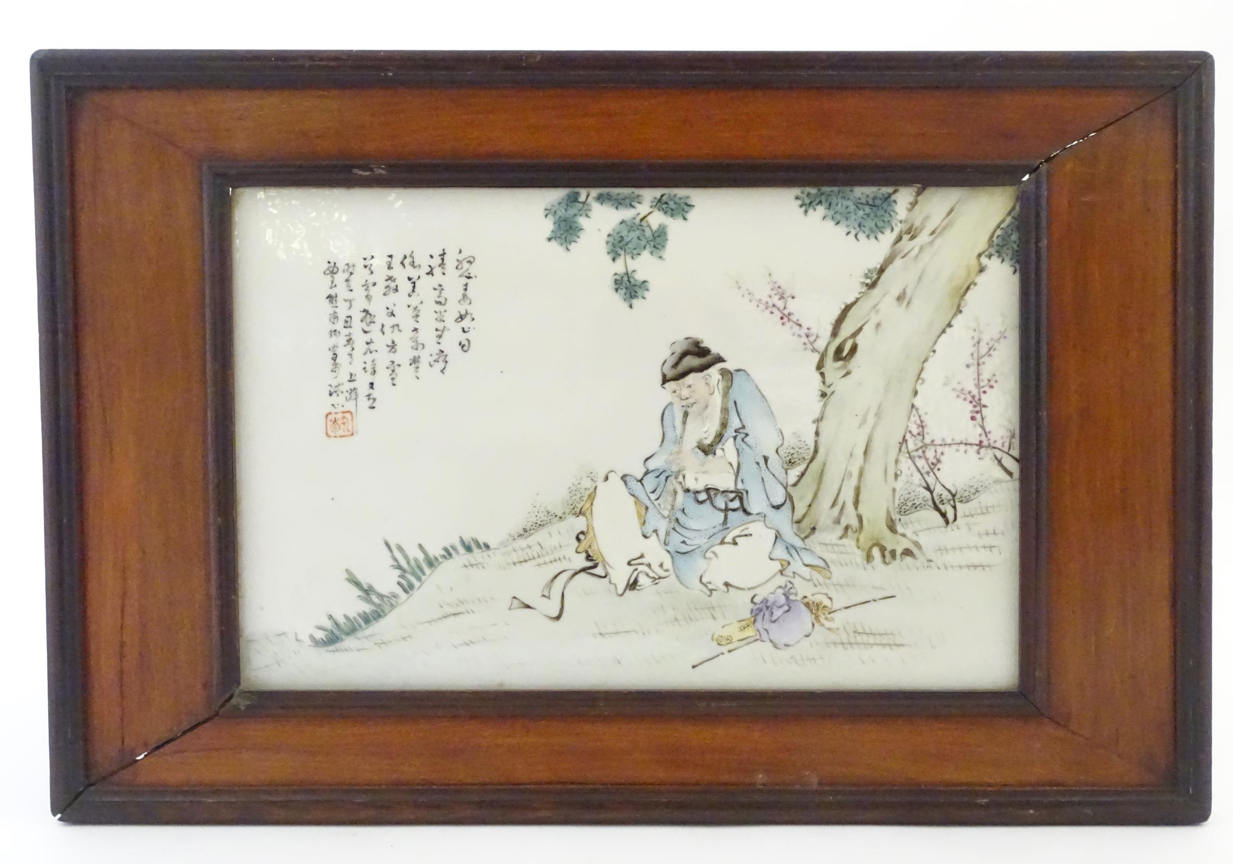 A Chinese porcelain plaque decorated with a seated elder / scholar beneath a tree, with Oriental